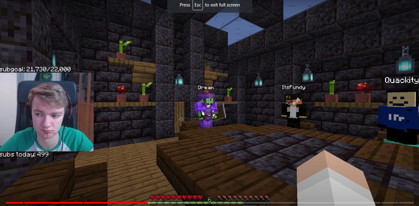 A screenshot taken from Tommy's stream. It shows himself, Dream, Quackity, and Fundy sitting around a wooden table in a black stone brick room. Tubbo and Ranboo are also present, but they are not seen in the picture. There are shelves in the background with various plants in pots. The room is lit up by soul lanterns and black stained glass skylights. Tommy's facecam shows he's not happy, but he's trying to remain civil.